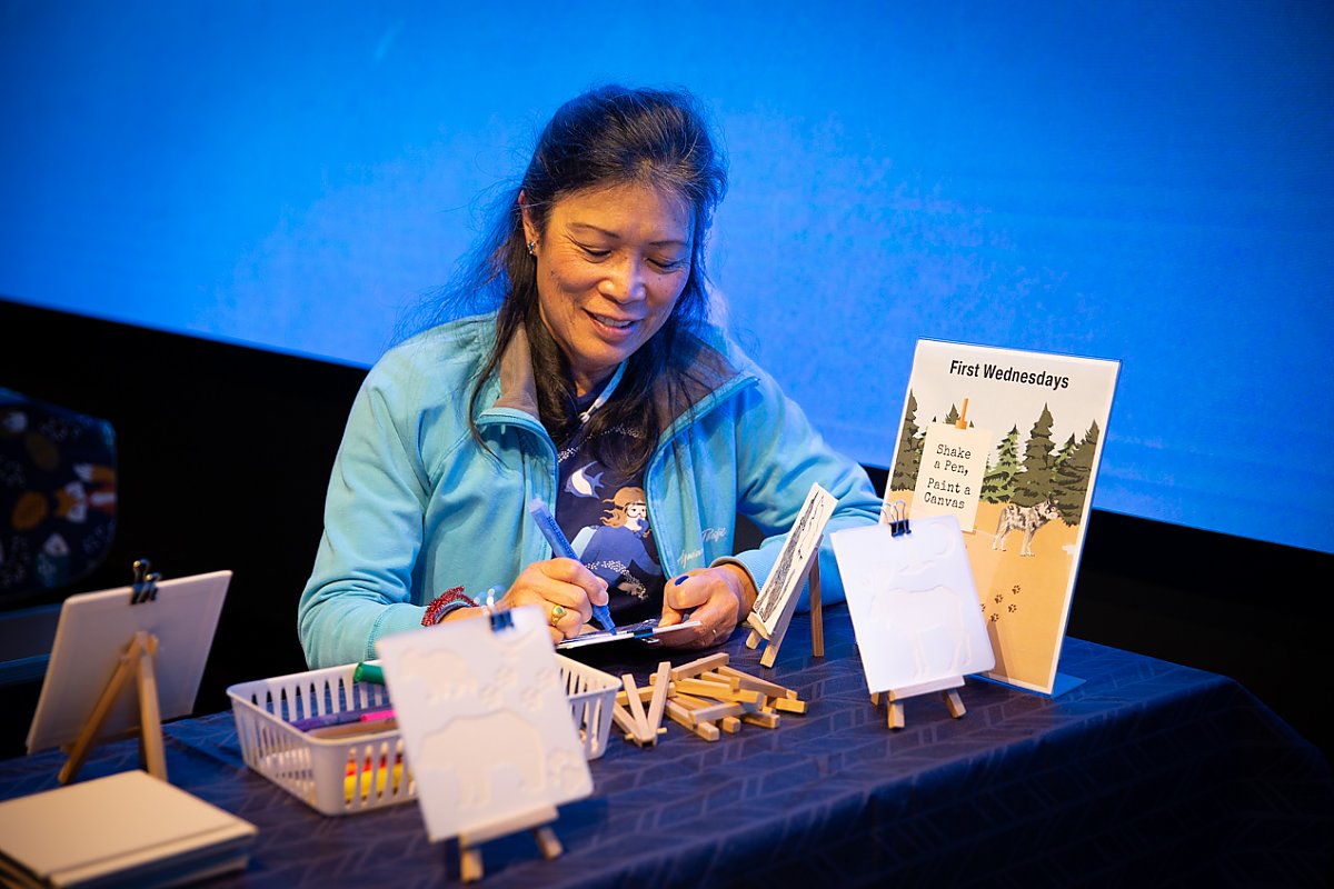 Woman at a craft table drawing